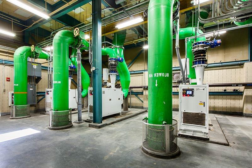 Large green pipes inside the facility and other controls/equipment.
